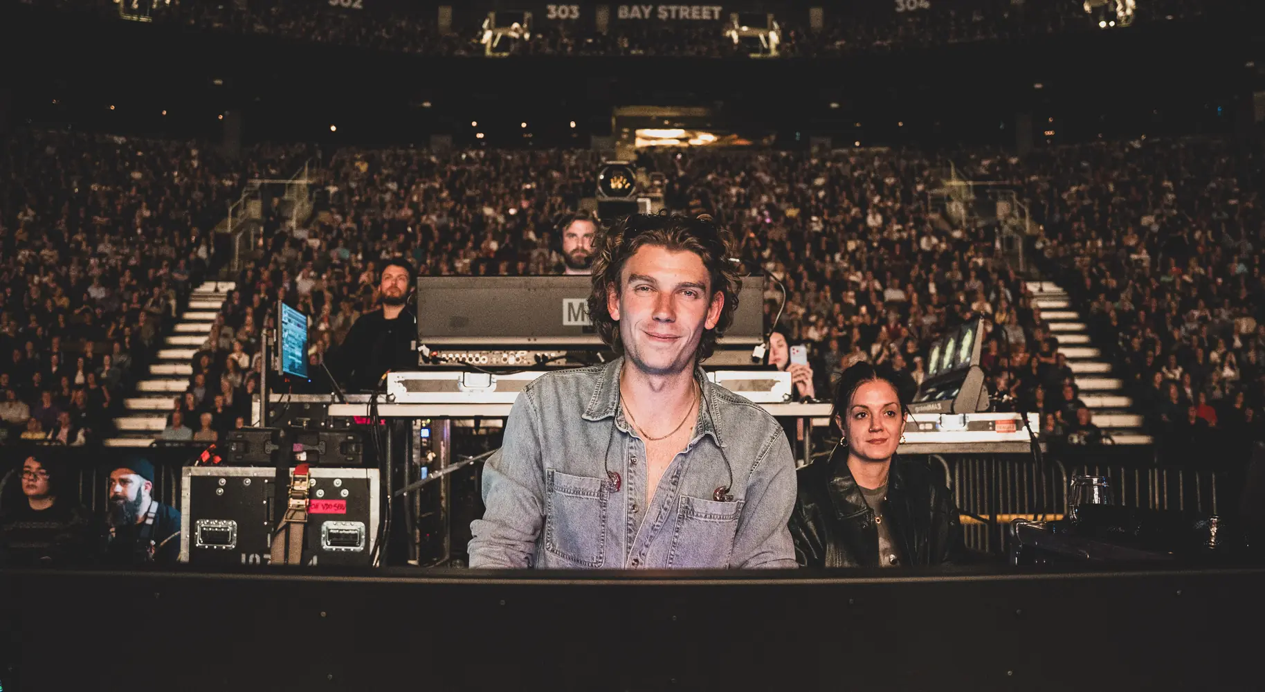 Tom at front of house in front of a packed arena